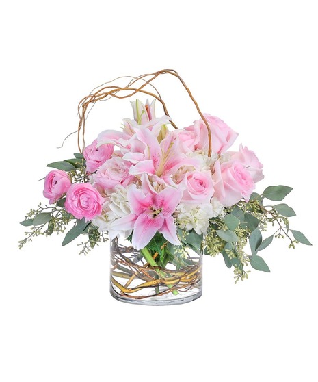 Curly willow encircles this combination of hydrangea, roses, lilies and ranunculus to draw attention to the premium delicate blooms in a clear glass cylinder