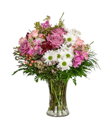 spray roses, daisies, lilies, and stock in a tall glass vase