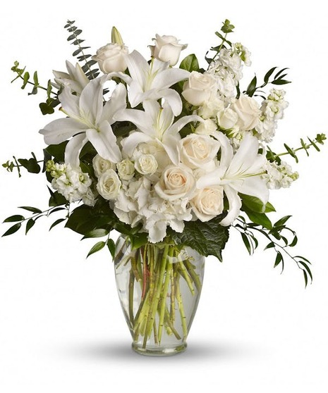 White and peach blossoms in a tall glass vase