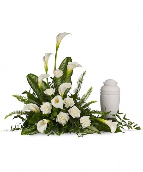 Majestic calla lilies and white roses are framed by the lush leaves of aspidistra, calathea and sword ferns.