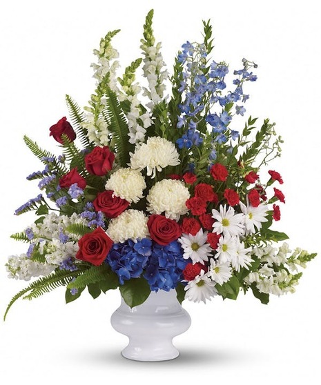 Red, white and blue flowers in a short white container