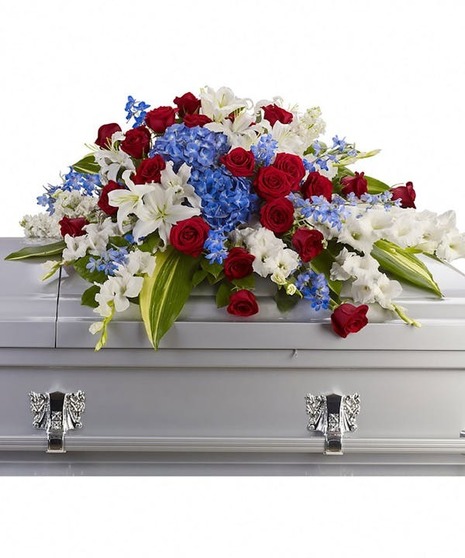 Red white and blue spray laid atop a casket.