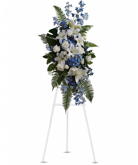 A standing spray with foliage and blue and white flowers.