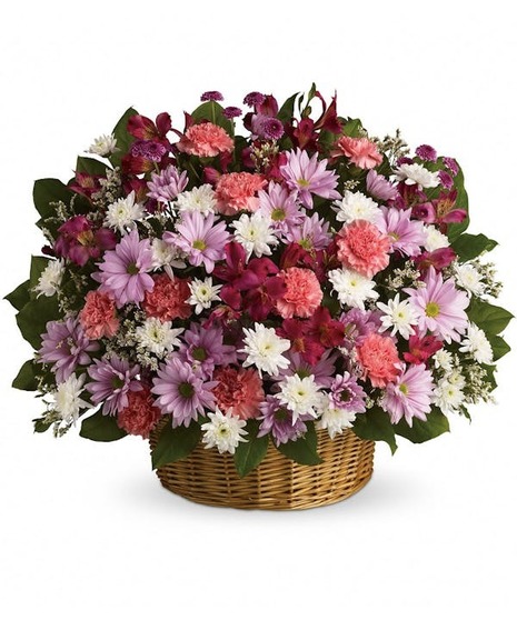 A wicker basket overflowing with various pastel flowers