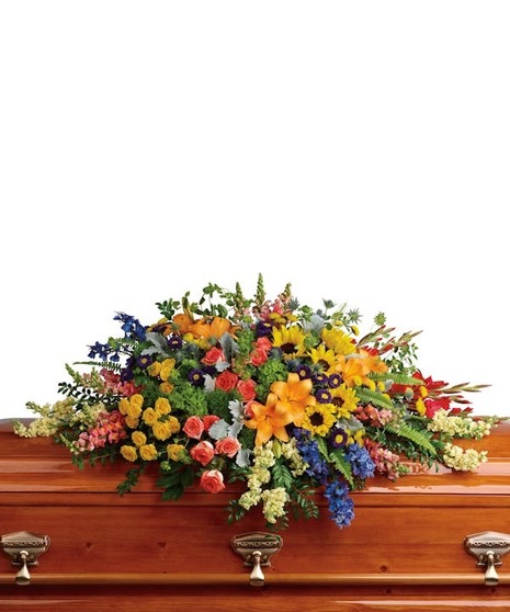 Hydrangea, roses, lilies and sunflowers arranged atop a casket